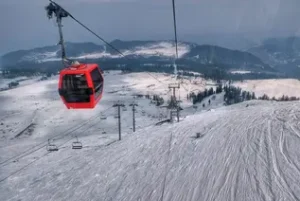 Tourists enjoying the Gondola Ride in Gulmarg Kashmir with scenic snow-covered mountains views