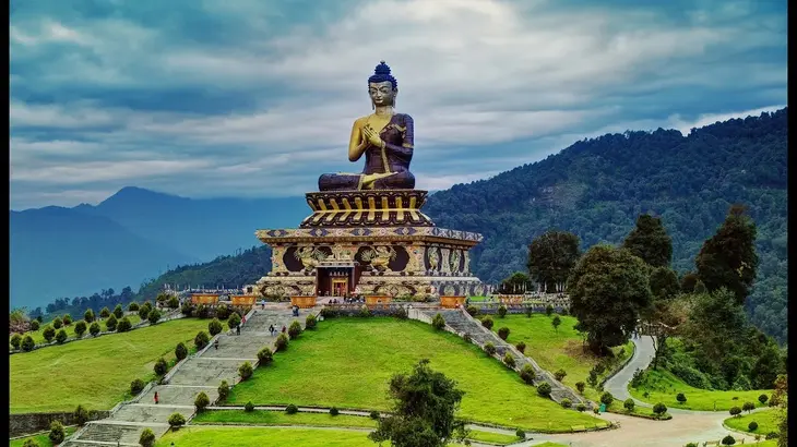 places to visit in Sikkim - giant Buddha statue at Ravangla Buddha Park with green hills and mountains in background